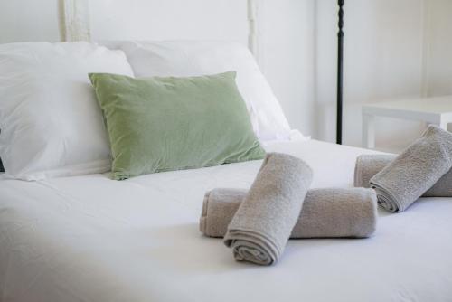 - un lit avec des draps et des oreillers blancs dans l'établissement Le Bazacle - Sublime Logement en Hypercentre, à Toulouse