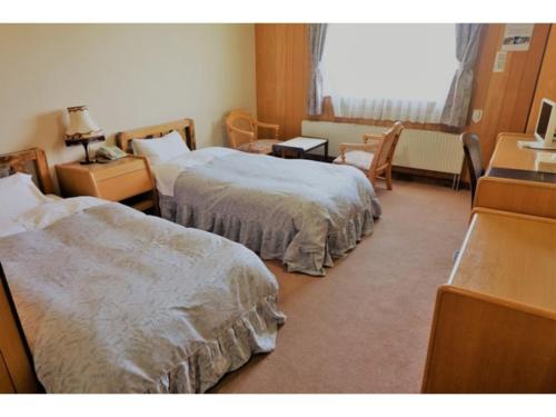 a hotel room with two beds and a desk at Hotel Takimoto - Vacation STAY 43486v in Yamanouchi
