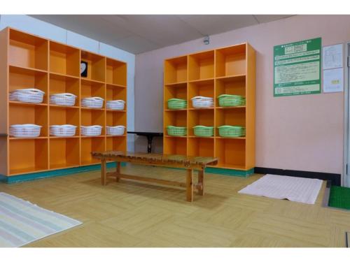 a room with yellow shelves and a wooden bench at Hotel Takimoto - Vacation STAY 43492v in Yamanouchi