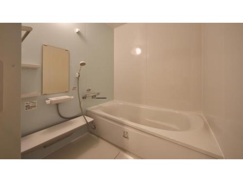 a white bathroom with a tub and a mirror at Hotel Takimoto - Vacation STAY 43488v in Yamanouchi