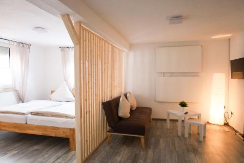 1 dormitorio con 1 cama, 1 silla y 1 mesa en Ferienwohnung zum Alten Fachwerk en Melsungen