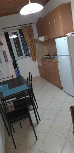 a small kitchen with a table and a refrigerator at Biky's room's in Moudhros