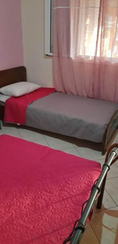 a bedroom with two beds and a red rug at Biky's room's in Moudhros