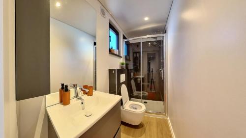 a white bathroom with a toilet and a sink at Kasthouse Luxury mobile home Orange in Mali Lošinj