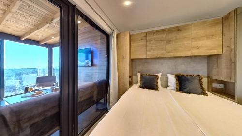Habitación con cama, escritorio y ventana. en Kasthouse Luxury mobile home Orange en Mali Lošinj