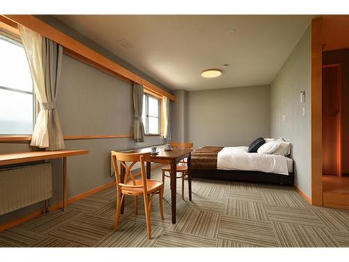 a room with a bed and a table and chairs at Hotel Takimoto - Vacation STAY 43491v in Yamanouchi