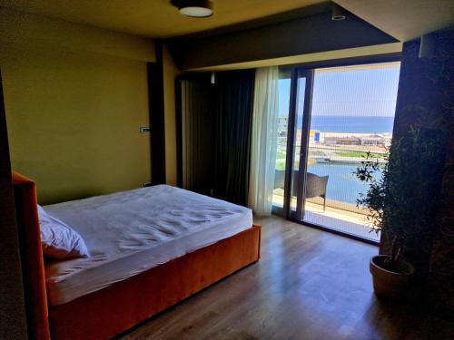 a bedroom with a bed and a view of the ocean at INLARG Holiday Apartment in Eforie Nord