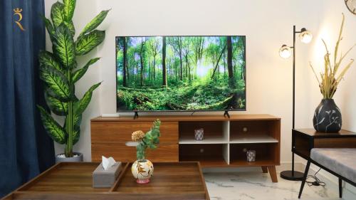 a living room with a flat screen tv at Stylish 2BR Duplex - Chic Masdar Modern Stay in Abu Dhabi