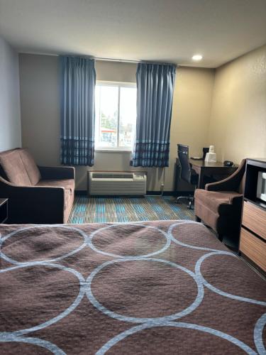 a living room with a large rug on the floor at Super 8 by Wyndham Escanaba in Escanaba