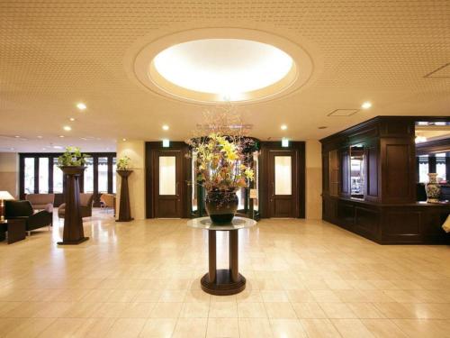 un vestíbulo con un jarrón de flores sobre una mesa en Suikoyen Hotel - Vacation STAY 46436v, en Kurume