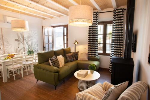 ein Wohnzimmer mit einem grünen Sofa und einem Tisch in der Unterkunft Casa Rural Candelas in Zahara de la Sierra