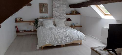 a bedroom with a bed with white blankets and pillows at La chambre de la maison du four à pain in Grandchamp