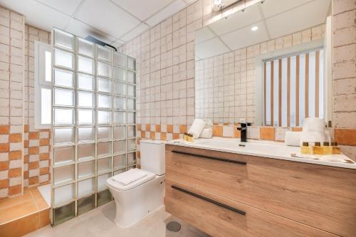 a bathroom with a toilet and a sink and a mirror at VACATION MARBELLA I Sunny Camelia Villa Heated pool in Benalmádena