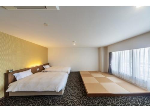 um quarto de hotel com duas camas e uma janela em Suikoyen Hotel - Vacation STAY 46475v em Kurume