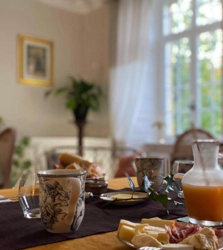 une table avec une assiette de nourriture et du jus d'orange dans l'établissement Au bord de l'étang - Le Presbytère, à Montaigu