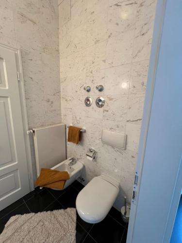 a bathroom with a white toilet and a sink at Ferienwohnung Marie in Bad Elster