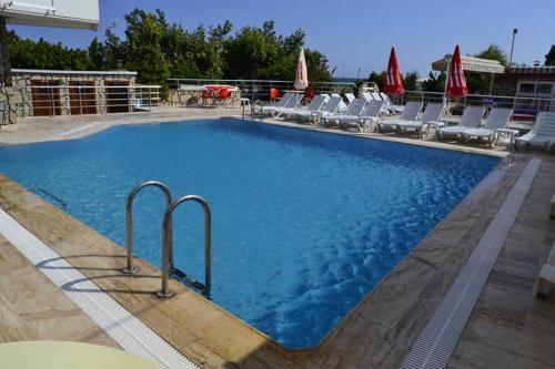 una gran piscina azul con sillas en Denizkumu Hotel, en Erdemli
