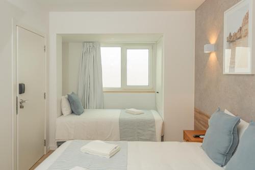 a hotel room with two beds and a window at Faro Heart Suites in Faro