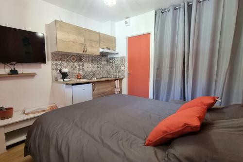 een slaapkamer met een groot bed met een oranje kussen bij Chez K&D StudioTerra in Saint-Raphaël