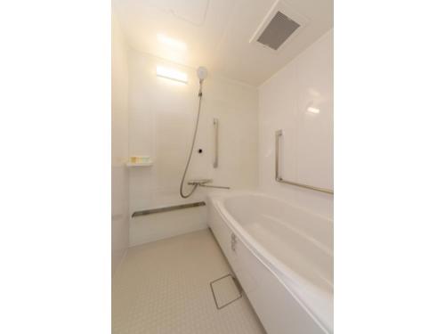 Baño blanco con bañera y espejo en Suikoyen Hotel - Vacation STAY 46467v, en Kurume