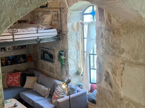 ein Wohnzimmer mit einem Sofa in einer Steinwand in der Unterkunft נרקיס NARKIS in Jerusalem