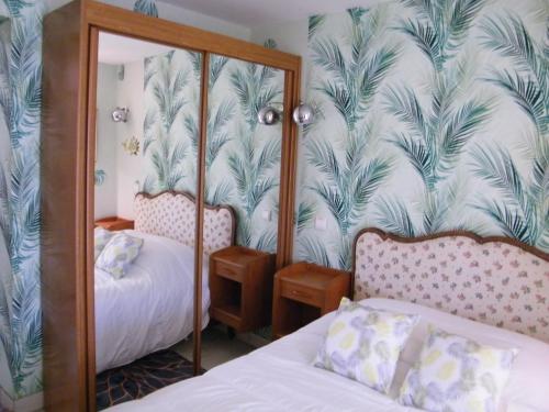 une chambre avec deux lits et un miroir dans l'établissement L'ARRA DE LA ROSERAIE, à Bonnebosq