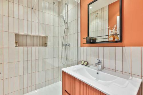ein Bad mit einem Waschbecken, einer Dusche und einem Spiegel in der Unterkunft Super appartement 4P 1BR Marché aux Puces in Saint-Ouen