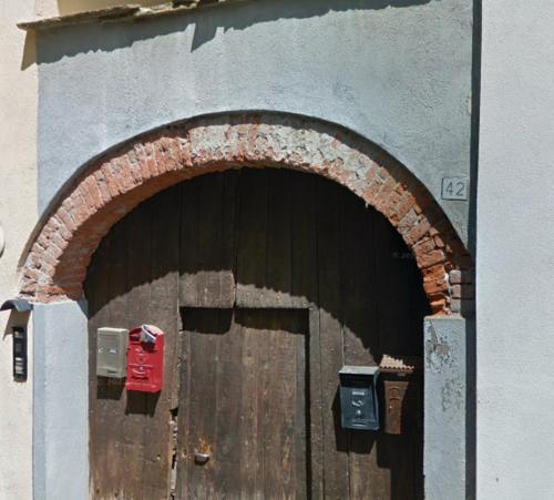 a wooden door with an arch in a building at [Casa Glicine] Centro Storico in Pinerolo