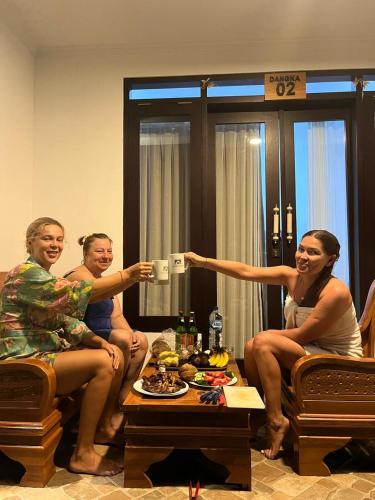 a group of women sitting in a living room taking a picture at Batur lake view in Kintamani