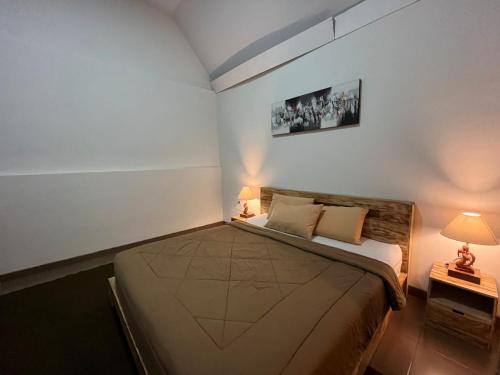 a small bedroom with a large bed with two lamps at Batur lake view in Kintamani