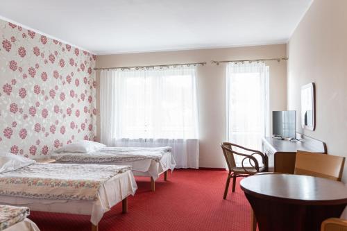 ジブヌベクにあるOśrodek Wczasowy Marevitaのベッド2台とテーブルが備わるホテルルームです。