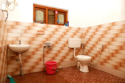 a bathroom with a toilet and a sink at HIlltop Cottage Homestay in Ooty