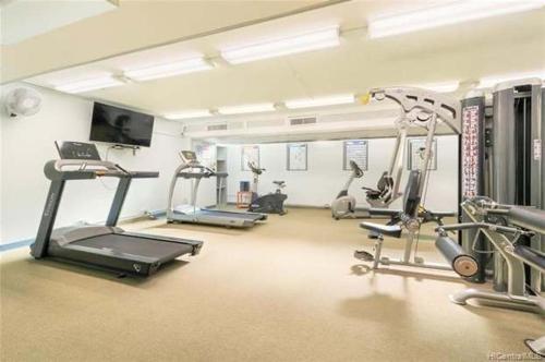 a gym with treadmills and machines in a room at Aston Waikiki Sunset Ocean view in Honolulu
