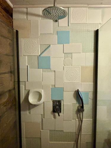 a bathroom with a toilet on a wall with blue and white tiles at Jak u babci na wsi in Siemichocze