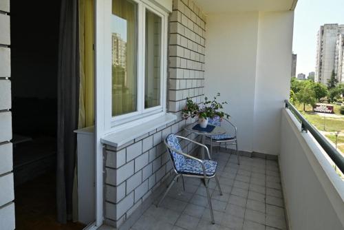ein Balkon mit Tisch und Stühlen und einem Fenster in der Unterkunft Apartment 601 in Surčin