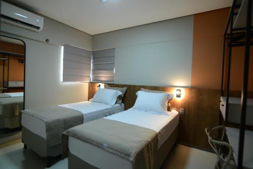 een kamer met 2 bedden in een kamer met bij Brisas Flat Style in Cuiabá