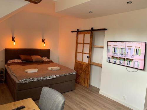 a bedroom with a bed and a table and a window at Dark Horse Apartament in Chojnice