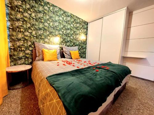 um quarto com uma cama com flores vermelhas em Zielony Zakątek em Koszalin