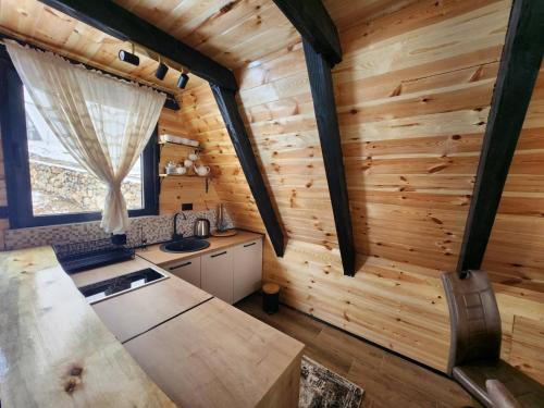 a kitchen in a log cabin with a window at Villas Sunny Hill in Žabljak