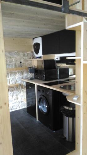 - une cuisine équipée d'un lave-linge, d'un évier et d'une cuisinière dans l'établissement Studio meublé proche conseil départemental du Jura, à Lons-le-Saunier