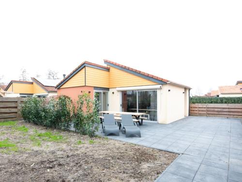 a patio with a table and chairs in front of a house at Holiday Home in Zevenhuizen with Sauna in Zevenhuizen