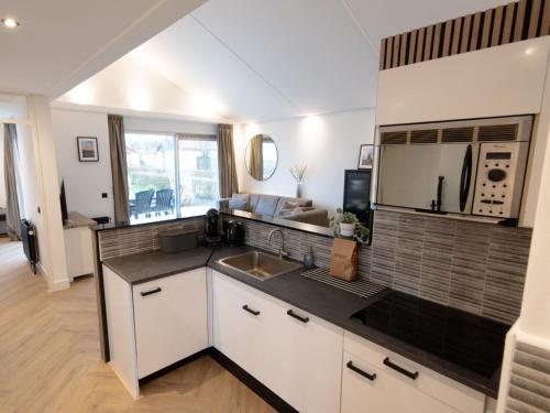 a kitchen with a sink and a microwave at Deluxe Canal-Side Stay in Zevenhuizen