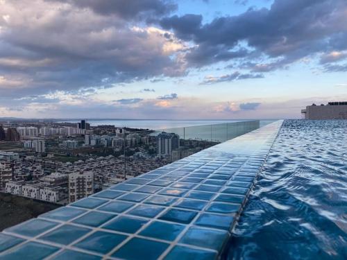 a swimming pool on top of a building with a city at Grand Sapphire 107 Amazing 1 Bedroom Apartment By MyGuest Cyprus in Iskele