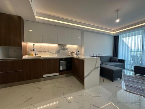 a kitchen and a living room with a couch at Grand Sapphire 107 Amazing 1 Bedroom Apartment By MyGuest Cyprus in Iskele