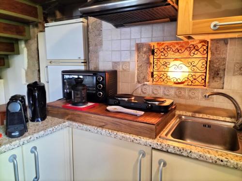 a kitchen with a microwave and a sink at La Piazzetta - Locazione turistica nel centro storico di Acquasparta in Acquasparta