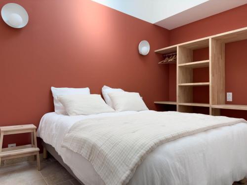 a bedroom with red walls and a white bed at Les suites du 13 in Aigues-Mortes