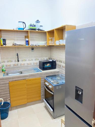 uma cozinha com um frigorífico de aço inoxidável e um lavatório em Bel appartement entier 2 chambres em Cotonou