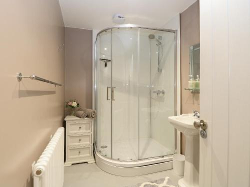 a white bathroom with a shower and a sink at West Farm in Great Yarmouth