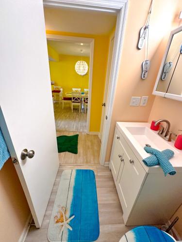 a bathroom with a sink and a room with a table at Modern Beachside Bliss: 2 Bed/2 Bath Condo Haven in Rehoboth Beach