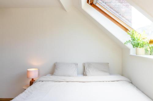 ヘントにあるGuesthouse private studio nearby old town Ghentのベッドと窓のある白い寝室